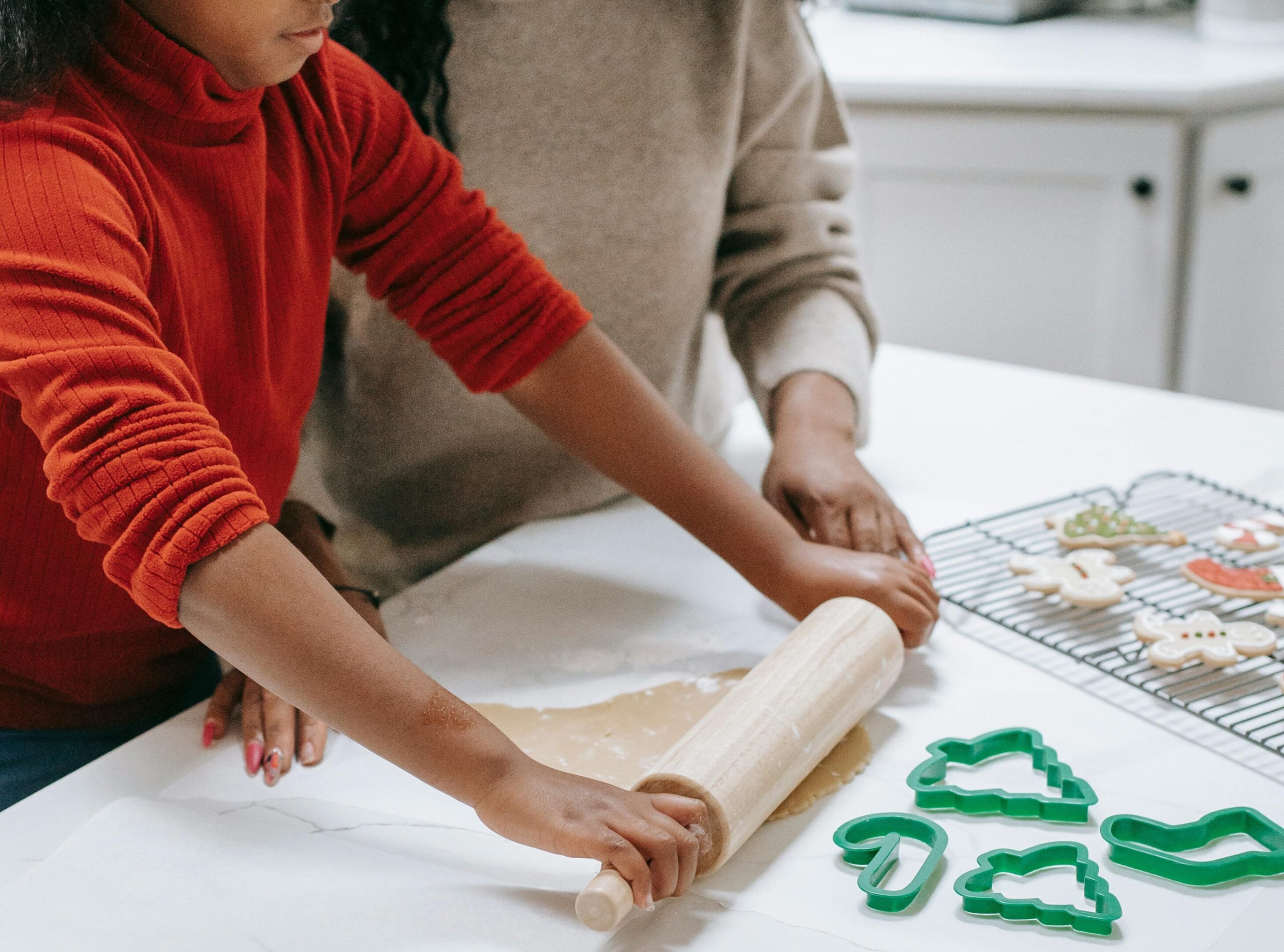 A man and child rolling dough on a table.