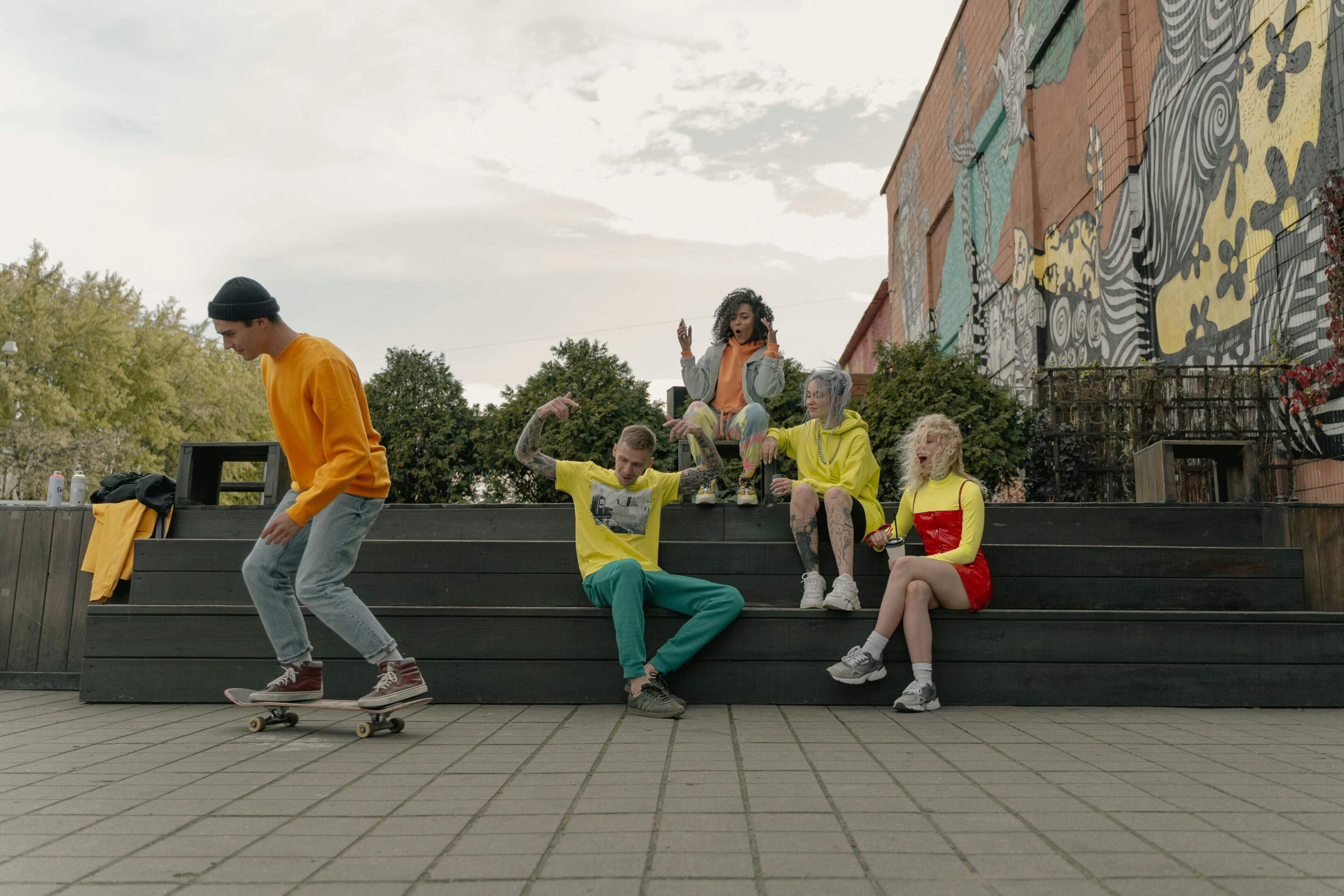 A group of kids sitting on steps with skateboards.