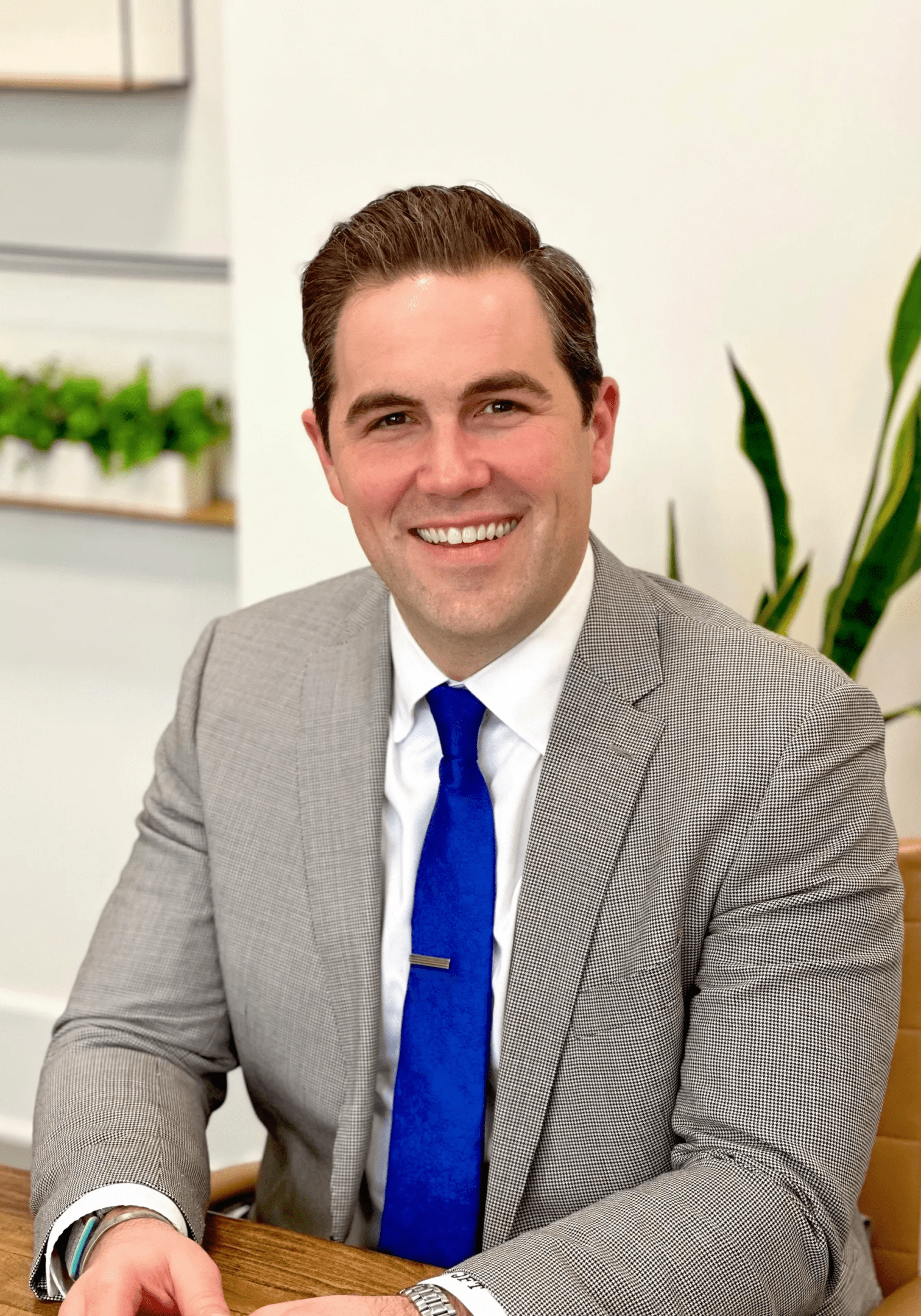 A man in suit and tie sitting down.