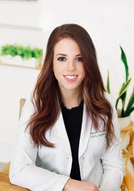 A woman in white lab coat sitting down.