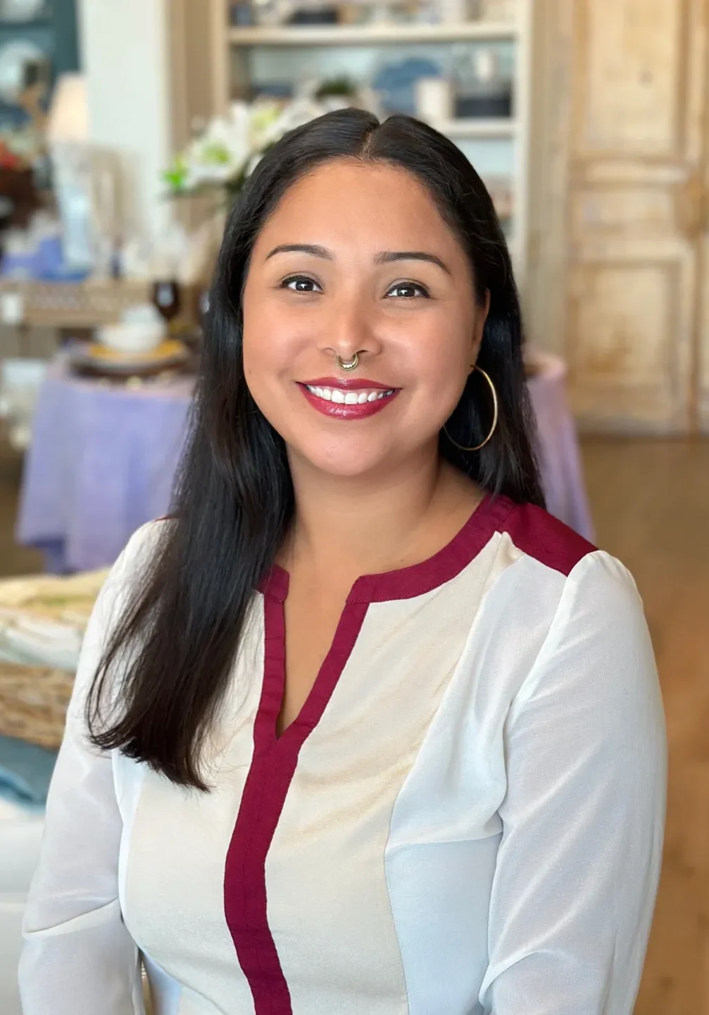 A woman with long black hair wearing a white shirt.